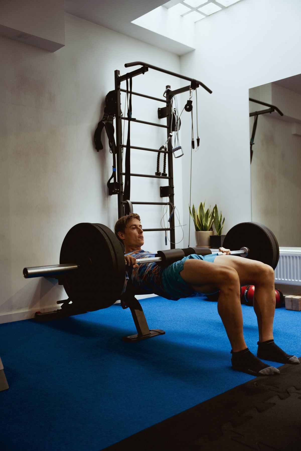 Trener koryguje ustawienie bioder podczas hip thrustu