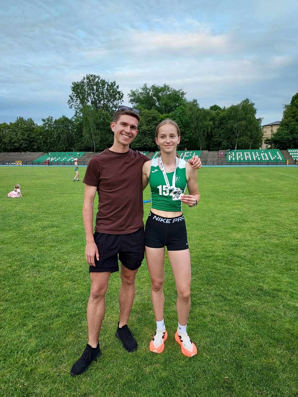 Szymon Dobaj z młodą zawodniczką na stadionie lekkoatletycznym